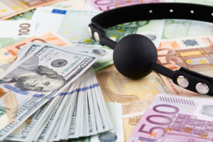 Black gag and heap of american dollars on euro banknotes.